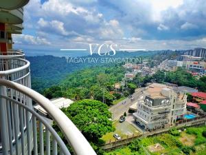 a view of a city from the balcony of a building at VCS Tagaytay Staycation in Tagaytay