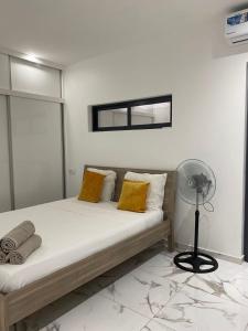 a bedroom with a bed with yellow pillows and a fan at Beach House in Calhau +29 photos
