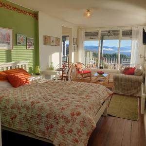 a bedroom with a large bed and a living room at Huon Belle Homestead in Waterloo