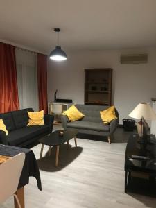 a living room with two couches and yellow pillows at Charmante maison individuelle in Orly