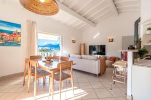un soggiorno con un tavolo e un divano di Casa Vinti - Vue mer et montagne climatisé a Porticcio