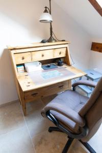 a wooden desk with a chair and a lamp at Ferienwohnung am alten Kino in Peißenberg +17 photos