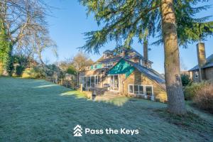 a house with a peaked roof on a grassy yard at Spacious, Modern Family Home I Pass the Keys in Pangbourne