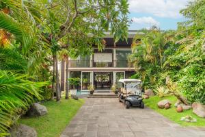 einem Golfwagen, der vor einem Haus parkt in der Unterkunft Javana Royal Villas in Seminyak