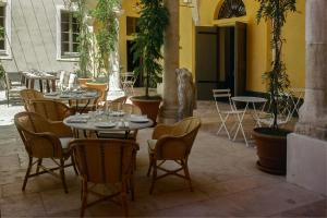 尼斯Hôtel du Couvent, a Luxury Collection Hotel, Nice的庭院配有桌椅,后方饲养着一只狗。