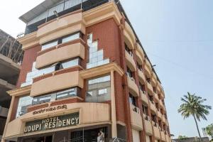 a tall red brick building with a sign on it at Hotel Udupi Residency near Shri Krishna Mata, Udupi in Udupi
