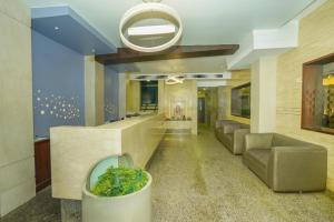 a lobby with a large plant in a pot at Hotel Udupi Residency near Shri Krishna Mata, Udupi in Udupi