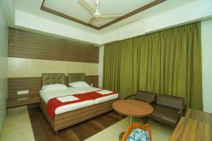 a bedroom with a bed and a table and chair at Hotel Udupi Residency near Shri Krishna Mata, Udupi in Udupi +24 photos