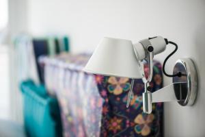 a lamp attached to a wall with a curtain at Hotel Cicò in Torre Santa Sabina