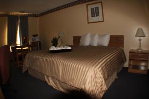 a hotel room with a bed with a tray on it at Value Inn & Suites - Harlingen in Harlingen