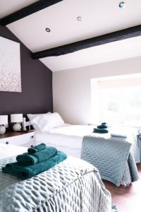 ein Schlafzimmer mit 2 Betten und grünen Handtüchern darauf in der Unterkunft Luxury modern canal side cottage for families, couples, contractors and dog friendly in Lancashire sleeps 6 in Preston