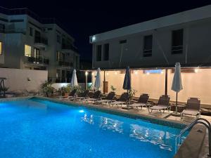 a swimming pool with chairs and umbrellas next to a building at Melia Mar in Sozopol