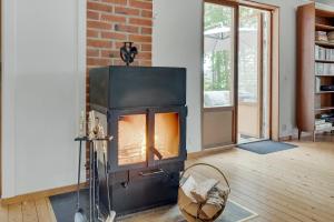 a fireplace in a living room with a brick wall at The Copper Cottage in Löddeköpinge