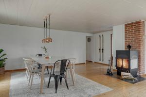 a dining room with a table and a fireplace at The Copper Cottage in Löddeköpinge
