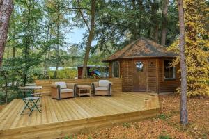 a wooden deck with chairs and a cabin at The Copper Cottage in Löddeköpinge