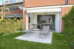 a patio with two chairs and a table in a yard at Appartamento San Zeno in Bardolino
