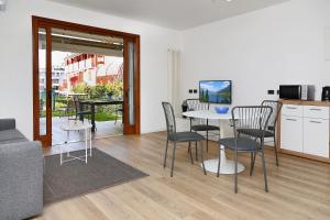 a living room with a table and chairs and a kitchen at Appartamento San Zeno in Bardolino