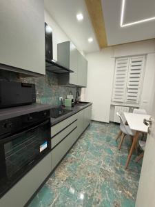 a kitchen with white cabinets and a table in it at Relax assoluto in Cremona