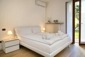 a white bed with two pillows on it in a room at Appartamento San Zeno in Bardolino