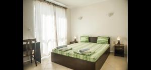 une chambre avec un lit et une grande fenêtre dans l'établissement Вила Арапя, à Tsarévo