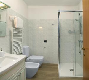 a bathroom with a toilet and a glass shower at Appartamento San Zeno in Bardolino +15 photos
