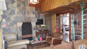 ein Wohnzimmer mit einem Steinkamin und Stühlen in der Unterkunft Family & Group Accomodation by Woodmere in Nairobi