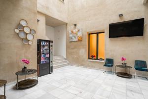 a lobby with a soda machine and a television at Center Suites San Eloy in Seville