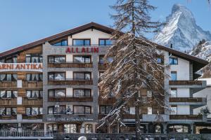 a hotel with a christmas tree in front of a mountain at Swiss Alpine Hotel Allalin in Zermatt