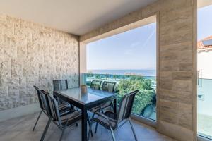 a dining room with a table and chairs and a large window at Villa Luce del Sole in Mirce