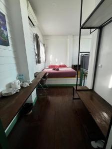 a bedroom with a bed and a wooden floor at Goodmorning by Tamarind in Phra Nakhon Si Ayutthaya