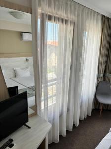a hotel room with a window and a television at Melia Mar in Sozopol
