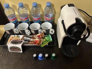 una cafetera con tazas y botellas de agua en una mesa en Apartments & Rooms Royal Plaza, en Borovets