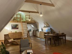 a room with a dining table and a loft with a ladder at In der Wassermühle in Melle