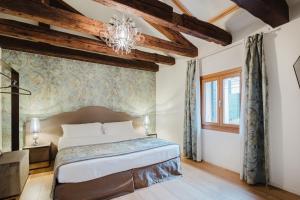 a bedroom with a large bed and a chandelier at Dimora Capuleti in Venice