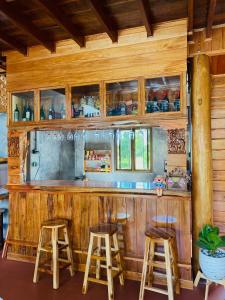 a wooden bar with stools in a kitchen at เรือนบรรเจิดโฮมสเตย์ in Ban Nok +15 photos