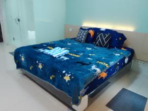 a bed with a blue comforter with animals on it at The Square - King Suite - Apartemen Service - 2Person - NetFlix Wifi - Near Petra Campus in Surabaya +21 photos