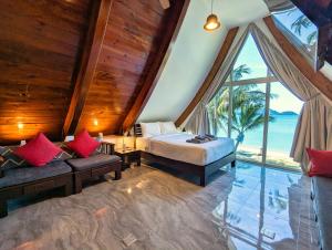 Ban Khlong SonにあるThe Beach House - by KohChangVillasのベッドと大きな窓のある寝室