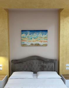 a bedroom with two beds and a painting on the wall at Relax assoluto in Cremona