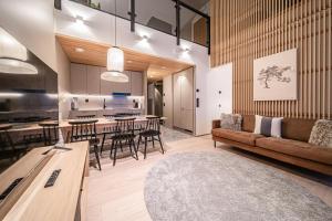 a living room and kitchen with a couch and a table at Horizon Chalet by Aavalevi Holidays, Ski-in Ski-out, Mountain view in Levi