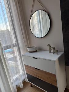 einen Spiegel auf der Kommode mit Fenster in der Unterkunft Boutique Home Magnolia in Goldstrand