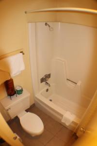 a bathroom with a toilet and a shower and a tub at Value Inn & Suites - Harlingen in Harlingen