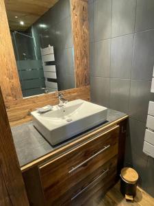 un bagno con un lavandino bianco e uno specchio di Chalet La Pioleute Megève a Megève Altre 15 foto