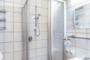 a shower with a glass door in a bathroom at Schwüwong - Apartment 21 in Kelchsau +28 photos