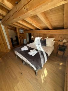 una camera con letto in una mansarda in legno di Chalet La Pioleute Megève a Megève