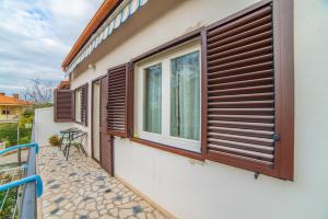 a building with a window with wooden shutters on it at Apartment Iva in Rovinj
