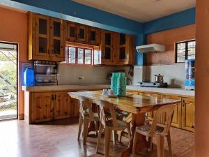 a kitchen with wooden cabinets and a wooden table at Mount Pulag SMR Homestay in Kabayan