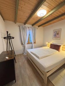 a bedroom with a large bed and a wooden ceiling at Familienchalets am Millstätter See in Rothenthurn