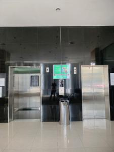 an airport baggage claim area with a stainless steel refrigerator at Apartment Elvis Tower Cikarang in Pegadungan