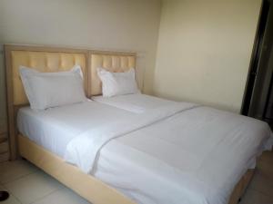 a white bed with white sheets and pillows at Apartment Elvis Tower Cikarang in Pegadungan