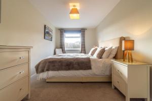 a bedroom with a bed with a dresser and a window at Number One in Chapel Stile